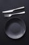 Empty plates and silverware on black background, premium tableware for holiday dinner, minimalistic design and diet