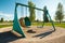 empty playground with swings, slide, and seesaw in the middle of summer day