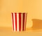 Empty popcorn bucket on an orange background