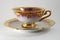 Empty porcelain tea cup with gilding on a white backdrop