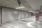 Empty public underground parking lot or garage interior with concrete stripe painted columns and signs.