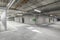 Empty public underground parking lot or garage interior with concrete stripe painted columns and signs.