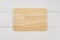 Empty rectangle wooden cutting board on white wooden table.