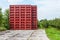 Empty red picking crates stacked near an orchard