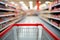 Empty red shopping cart in the foreground, with a blurry supermarket aisle