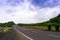 Empty road borded by hills with cloudy skies