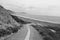 Empty road leading down on azkorri beach in black and white, basque country, spain