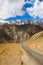 Empty road leading towards a snow capped mountain.