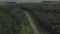 An empty road in the woods. Flight up over river. Aerial landscape