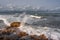 Empty rocky beach and stormy sea in cloudy weather