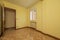 Empty room with an aluminum window, radiator in a niche, varnished oak parquet flooring and wooden doors