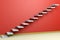 Empty room with ascending stairs with red wall diagonl view