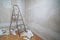 Empty room with bare walls ladder and old wallpaper scraps on floor during redecoration wth copy space
