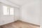 empty room with barred window and aluminum radiator, white painted walls
