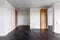 Empty room with dark wooden floating laminate flooring. House interior, wide bedroom or living room space. Newly recently painted