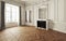 Empty room of an elegant residence with fireplace ,white trim Victorian accent interior space and herringbone wood flooring.