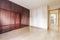 An empty room with a five body glossy mahogany wardrobe with oak hardwood floors