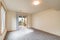 Empty room with gray carpet white walls wood trim sliding glass door to deck with stairs leading to backyard