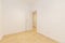 Empty room with light oak parquet floors, white carpentry