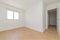 Empty room with light wooden floors, freshly painted plain white walls