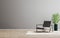 Empty room mock up with gray armchair and green plant, empty gray wall and wooden floor, gray room interior background,