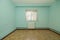 Empty room in an old apartment built with modest qualities, blue painted walls and white aluminum radiator