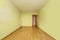 Empty room in an old flat built with modest qualities, pistachio green painted walls and wooden floors