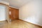 Empty room with old-style glossy wooden wardrobe and French oak parquet floor laid in a herringbone pattern