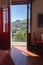 Empty room with open balcony doors. Living room with beautiful mountain view. Cozy apartment on sunny day.