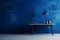 Empty room with plant with minimalist table and shadows. Textured blue wall copy space. Wall scene mockup product for showcase,