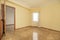 Empty room with shiny oak hardwood floor, matching woodwork, cream walls