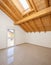 Empty room with a sloping roof and wooden beams