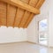 Empty room with a sloping roof and wooden beams