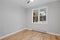 Empty room with sophisticated hardwood floors and neutral light gray walls