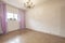 Empty room with white painted walls, wood-look sintasol floor and white aluminum windows with pink curtains