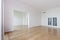 Empty room with whitewashed floating laminate flooring and newly painted white wall in background