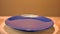 Empty rotating blue plate on wooden stand on orange background. empty plate is spinning. selecktive focus
