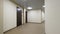 Empty, round corridor with light beige walls and closed, dark brown doors. Closed doors along a lighted corridor in the