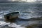 Empty rowboat floats lonely on the sea waves to the clouds at th