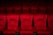 Empty rows of red theater or movie seats.