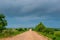 An empty rural clay road in rainy weather