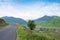 Empty rural road in mountains with morning blue cloudy sky