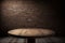 Empty rustic brown wooden table against a brick wall, background for still lifes and other compositions, Generative AI