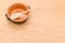 empty rustic terracotta kitchen bowl and spoon on a wooden tabletop