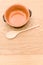 empty rustic terracotta kitchen bowl and spoon on a wooden tabletop