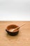 empty rustic terracotta kitchen bowl and spoon on a wooden tabletop