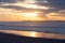 Empty sand beach at sunset, huge waves, and beautiful cloudy sky on background