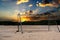 Empty sand soccer field on the background of the sunrise