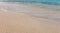 Empty sandy beach in Greece, close up. Sea water touch wet white sand, copy space. Summer holiday