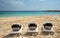 Empty sandy tropical beach with relaxed sun beds chairs
